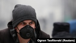 Një person ka vendosur një maskë në fytyrë për t'u mbrojtur nga ndotja e lartë e ajrit në Shkup. Fotografi nga arkivi.