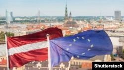 Сьцягі Латвіі і Эўразьвязу на фоне Рыгі