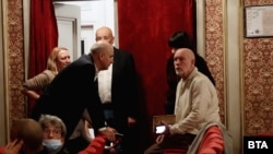 John Malkovich (dreapta) vorbește cu directorul teatrului, Vasil Vassilev (stânga), în timpul protestului în desfășurare în fața teatrului.