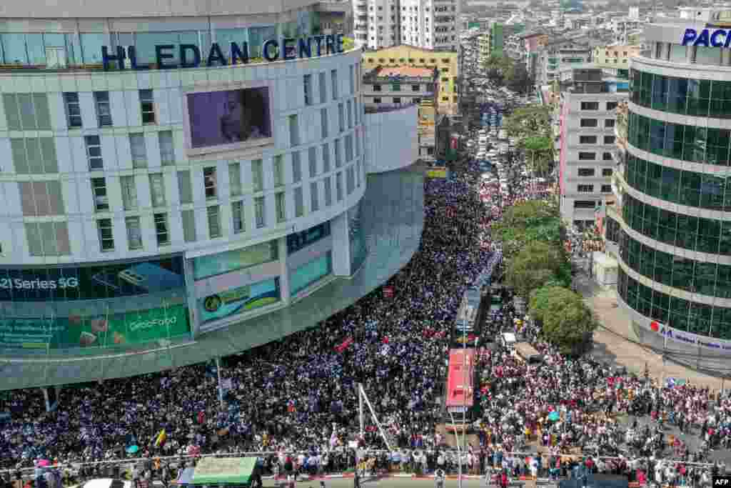 Această fotografie arată protestatari care participă la demonstrații în Yangon. (Photo by STR / AFP)